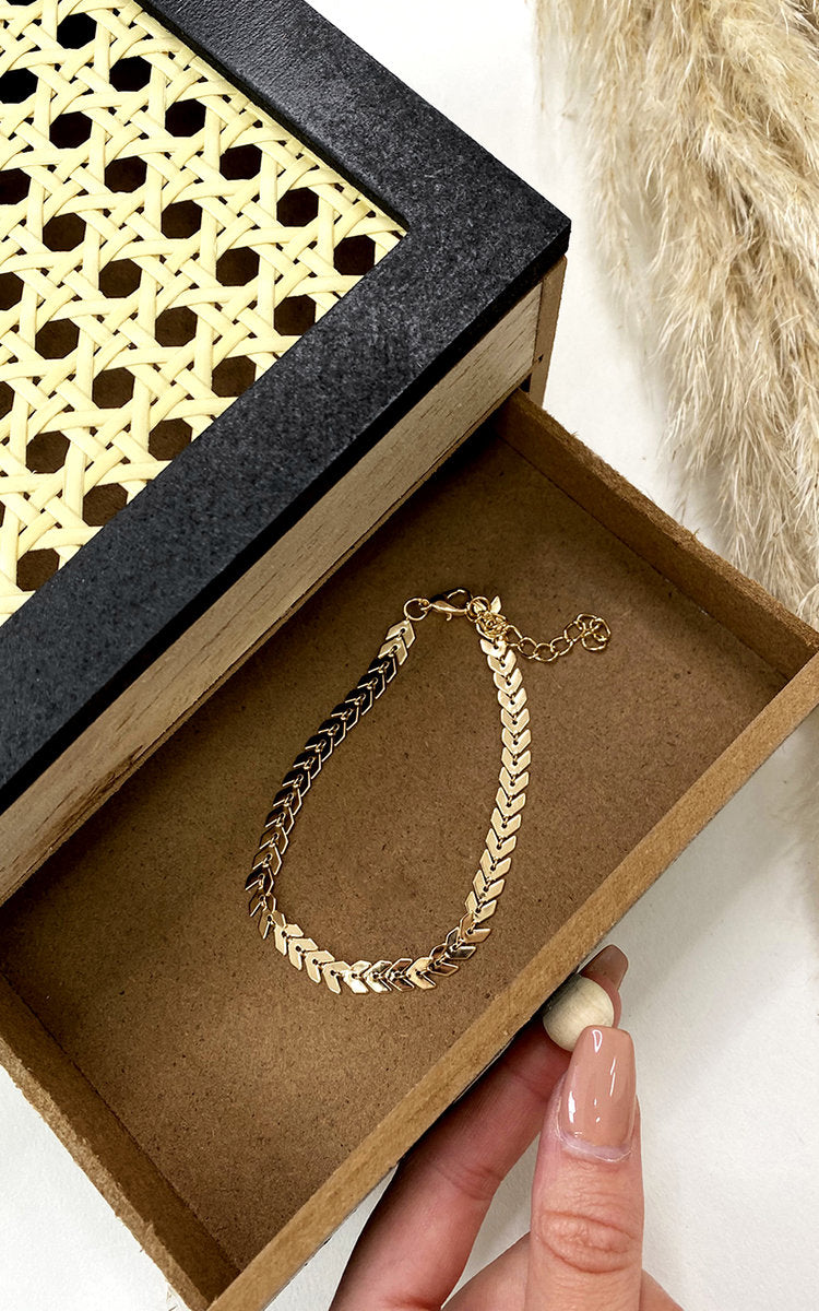 Chevron Anklet by Clarizzma in gold, featuring a delicate chain with a chevron pendant. Adjustable for a perfect fit, ideal for elegant styling.